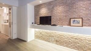 Eine moderne Küche mit einer Steinwand, einem Flachbildfernseher und integrierten Schränken.
