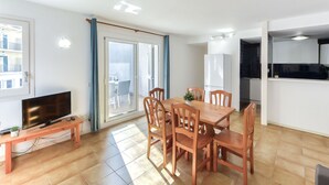 En moderne lejlighed med spiseområde, køkken og balkon.