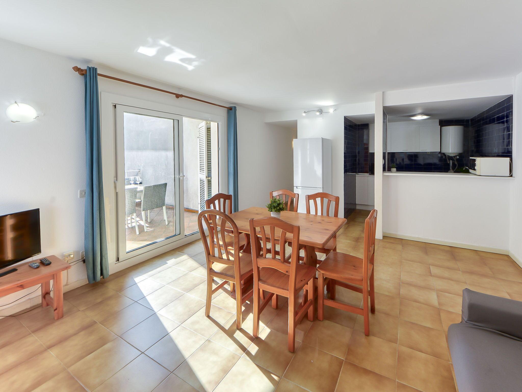 A modern apartment with a dining area, kitchen, and a balcony with a view.