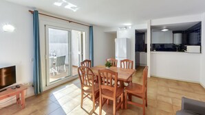 En moderne lejlighed med spiseområde, køkken og en balkon med udsigt.