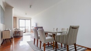 A modern dining area with a glass table, six chairs, and a striped rug. - Vista do Mar, Ótimo Local na Beira-mar Norte (Florianópolis)