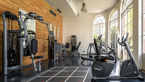 Una sala de gimnàstica amb equip d'exercici, un joc de tebres i grans finestres.