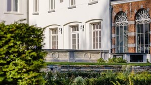 Edifici de dues plantes amb façana simètrica, que destaca una entrada central amb una porta i finestres a cada costat.