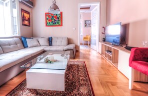 Leilighet – deluxe, 1 soverom, hageutsikt | Oppholdsområde | En 56-tommers smart-TV med kabel-kanaler samt TV og MP3-dokkingstasjon