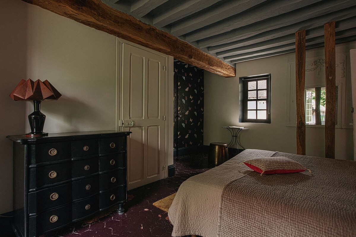 Un dormitorio con cama, cómoda, lámpara, ventana y puerta.