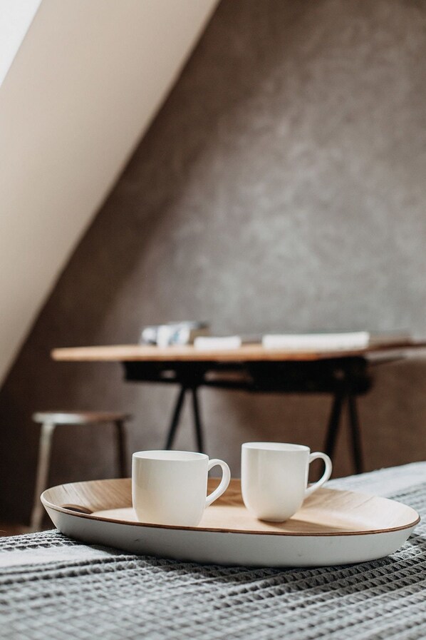 A cozy room with a wooden table and two white cups on a plate.