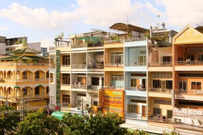 Un immeuble à plusieurs étages doté de balcons, une enseigne indiquant un centre de massage et, au fond, une pagode traditionnelle.