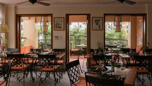 A restaurant with tables and chairs, ceiling fans, and framed pictures on the walls. - The Lighthouse (Can Tho)