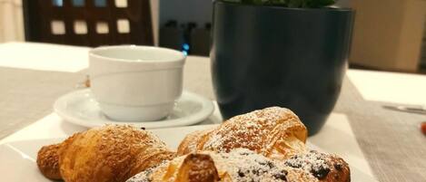 Un plato con cruasanes y una taza de café sobre una mesa.