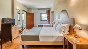 A hotel room with a bed, a desk, a television, and a window with curtains. - Hotel PentHouse (Perugia)