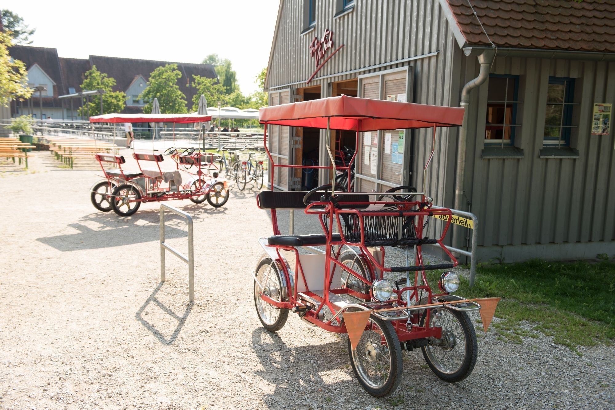 Vintage tricycles parked in front of a building with a sign that reads "Vogel".