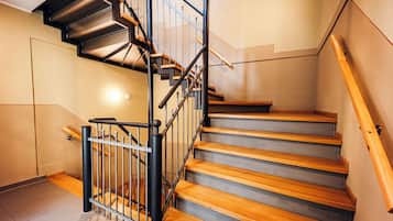 A staircase with wooden steps and metal railings, leading to an upper floor.