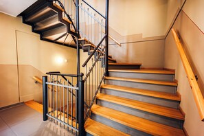 A staircase with wooden steps and metal railings, leading to an upper floor. - Brera Serviced Apartments Leipzig (Leipzig)