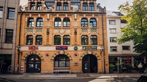 Un edificio histórico con varias fachadas comerciales, incluyendo un bar y un restaurante.