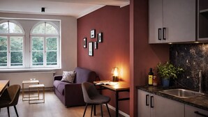 A modern kitchen with a built-in stove, a sink, and a window with a view of trees. - Brera Serviced Apartments Leipzig (Leipzig)