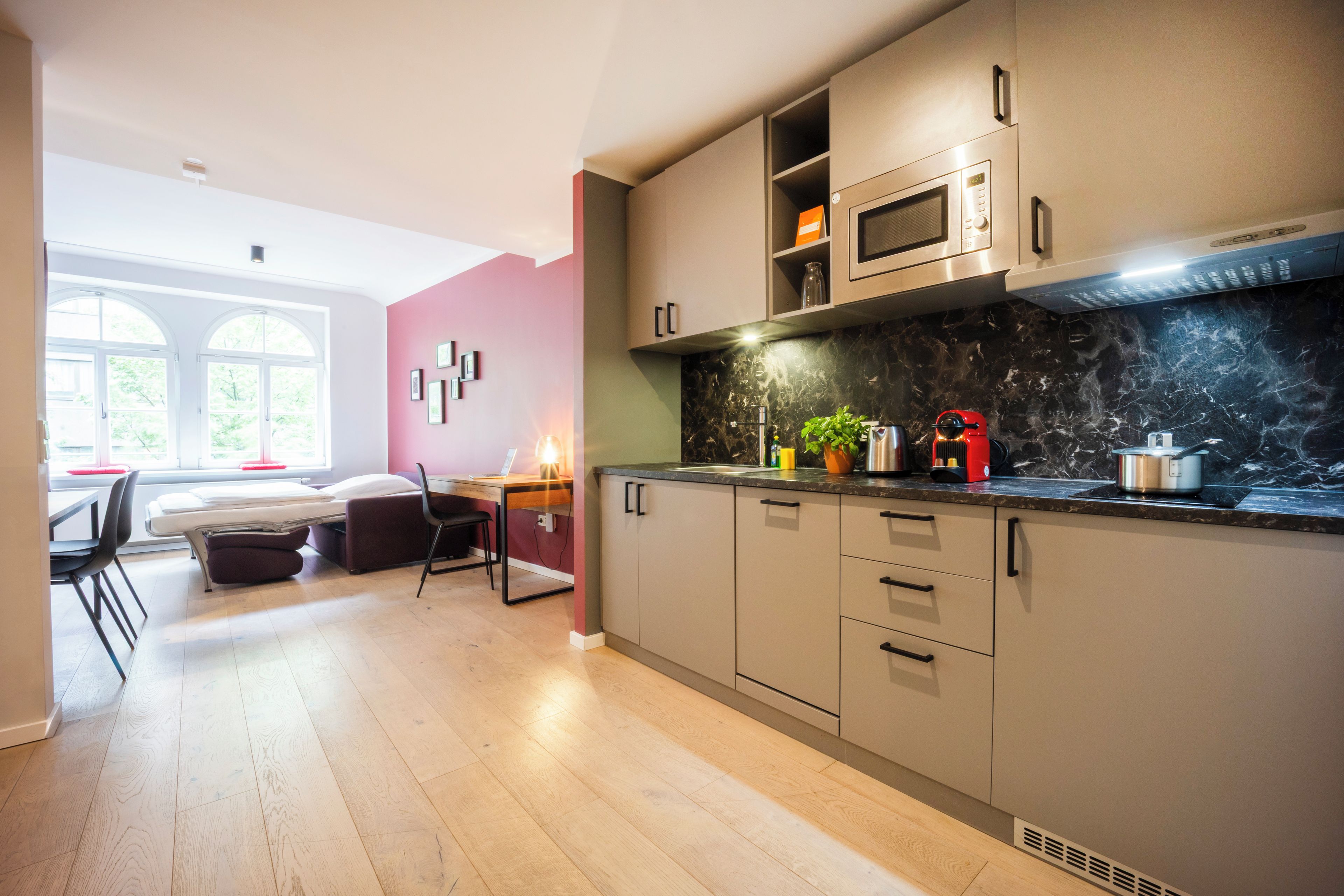 A modern kitchen with a microwave, stove, and cabinets. There is a dining area with a table and chairs.