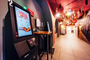 Un quiosco de autoservicio con pantalla digital, mostrador de madera y un escáner.