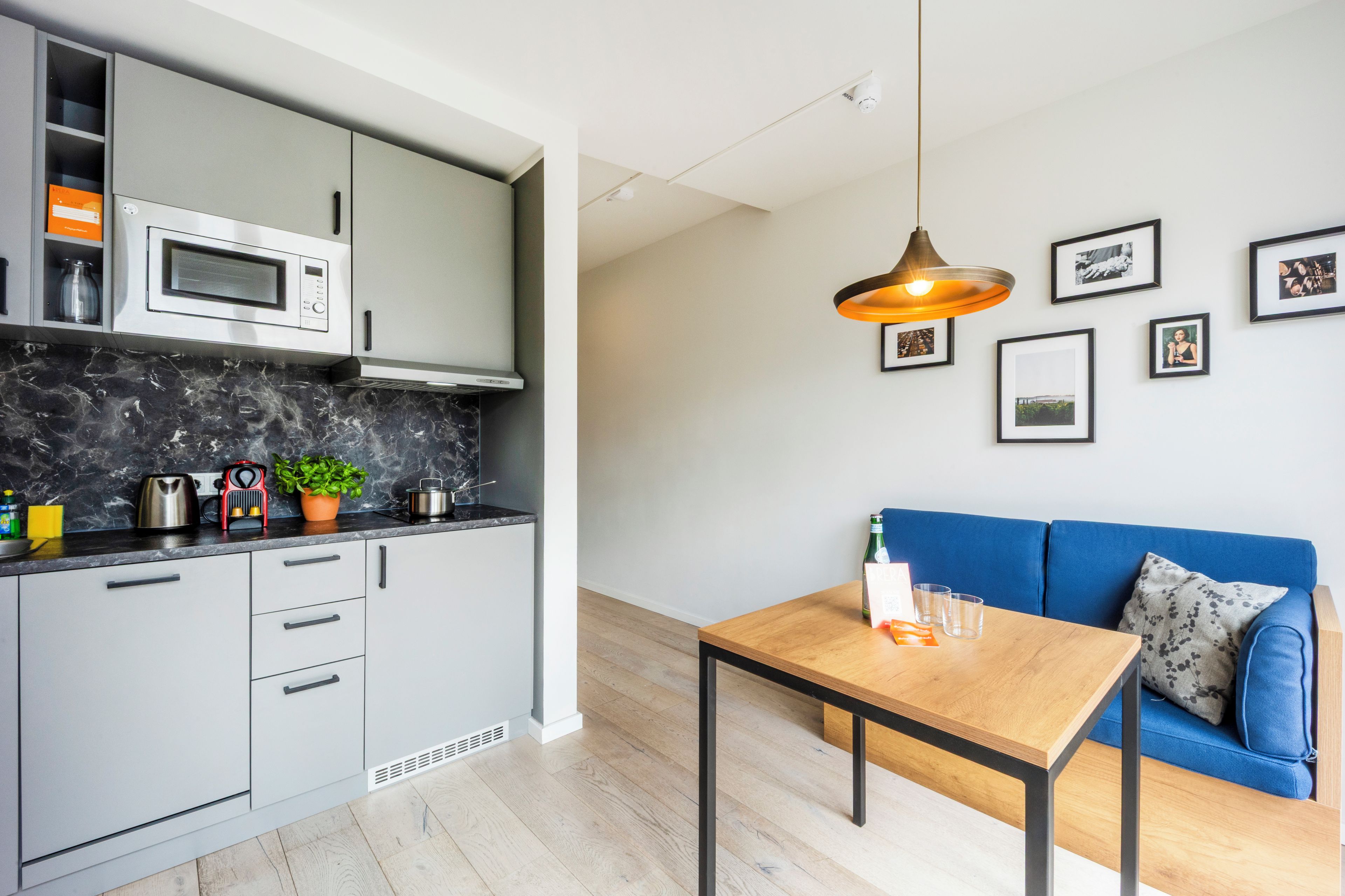A modern kitchen with a microwave, kettle, and a coffee machine on the counter.