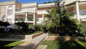 A multi-story hotel with balconies, a stone pathway, and palm trees. - Eden Cap by Interhome (Antibes)