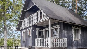 A wooden cabin with a porch and steps leading up to it. - Piilopirtti by Interhome (Kaavi)