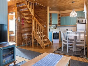 A wooden interior with a staircase, kitchen, dining area, and a television. - Noukatti by Interhome (Sotkamo)
