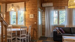 Ein gemütliches Blockhauss-Interieur mit Essbereich, einer Couch und einer Treppe.