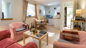 A cozy living room with a dining area, kitchen, and a view of the outdoors. - Lorn Mill by Interhome (Balloch)