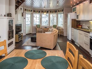 Un salon confortable avec un canapé, un téléviseur et une table à manger agrémentée de sets de table.