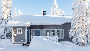 A house covered in snow with a clear blue sky.