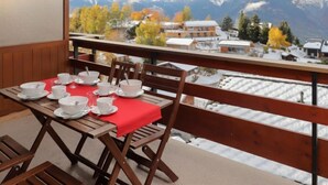 A balcony with a table set for dining, overlooking a snowy mountain landscape. - Quille du diable 19 by Interhome (Nendaz)