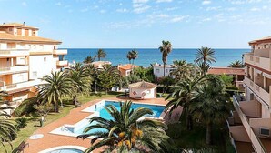Ein Resort mit mehreren Gebäuden, einem Schwimmbad und Palmen.