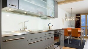 A modern kitchen with grey cabinets, a stainless steel sink, and a kettle on the counter. - Breithorn Residence Apt.3 by Interhome (Wengen)