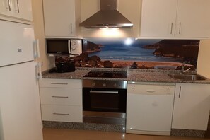 Eine Küche mit Mikrowelle, Herd, Backofen und Geschirrspüler.