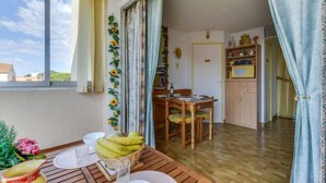 Un comedor con una mesa de madera, sillas y vistas al cielo a través de una ventana.
