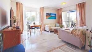 A spacious living area with a dining table, sofa, and a painting of a beach scene. - Lorcrimar II by Interhome (Marbella)