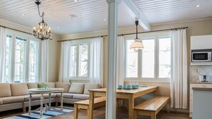 A spacious living area with a sofa, a dining table, and a kitchen area with a microwave. - Villa akuliina by Interhome (Multia)
