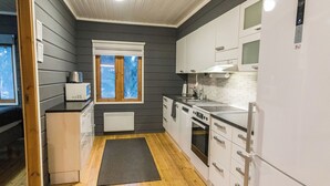 Kompakti keittiö, jossa on mikroaaltouuni, liesi ja jääkaappi.