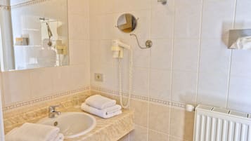 Un bany amb rentatge, mirall, paraigua i plat de dutxa amb aixeta manual.