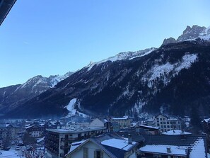 Eine Berglandschaft mit schneebedeckten Gipfeln und einer Stadt darunter.