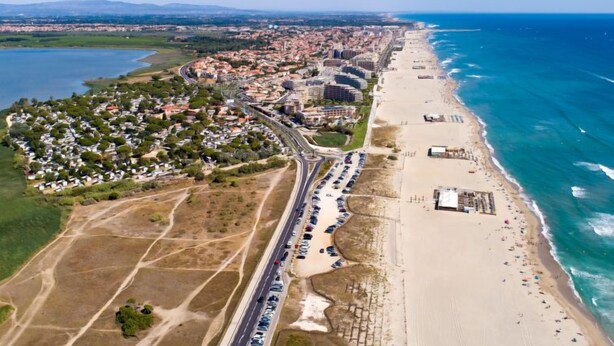 An aerial view of a coastal city with a beach, a highway, and residential areas. - Les Amandiers by Interhome (Canet-Plage)