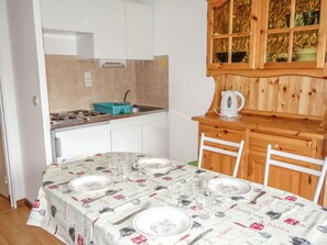 Een koelkast, een oven, een broodrooster, kookgerei, borden en bestek