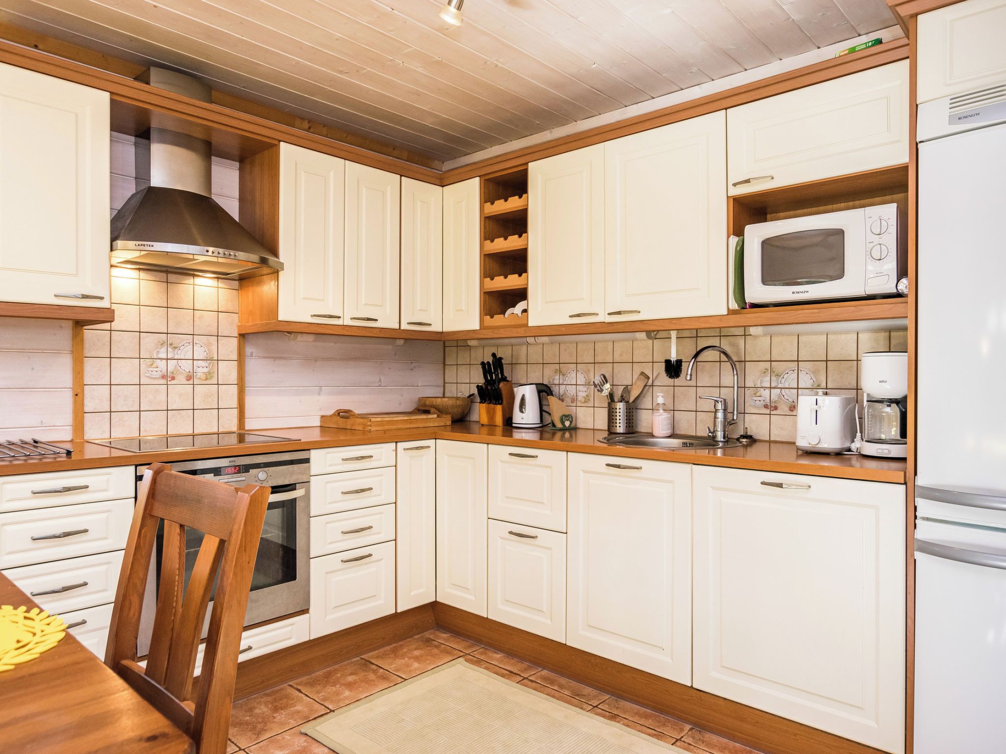 A kitchen with white cabinets, a microwave, a stove, and a sink.