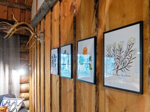 A wooden wall with framed pictures and a mounted deer head.