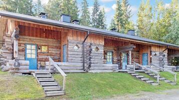 A log cabin with multiple rooms, each with a door and window, and a staircase leading to the entrance.