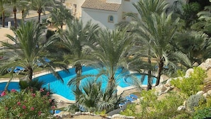 A pool surrounded by palm trees and a building with multiple balconies. - Altea Dorada by Interhome (Altea)