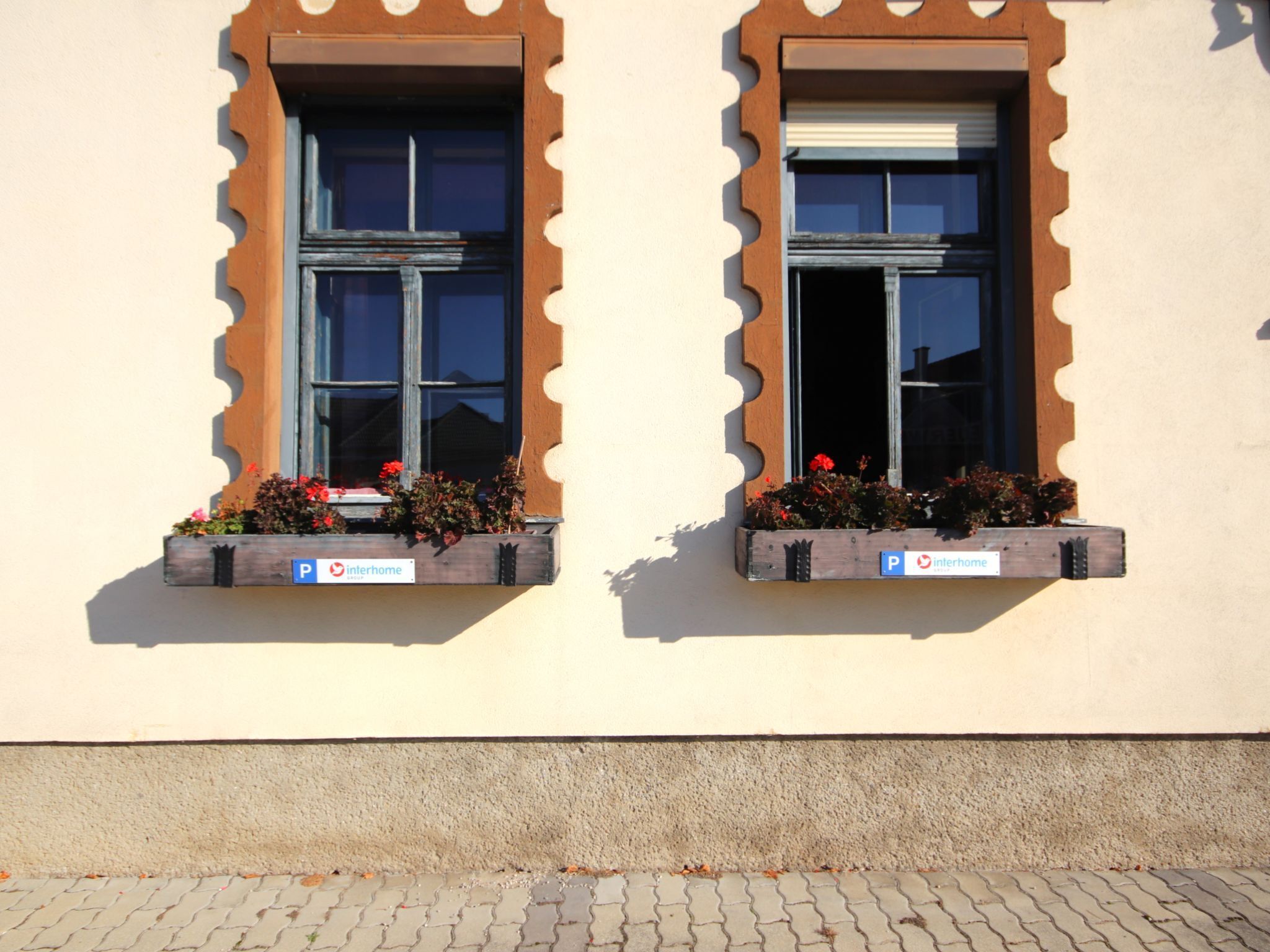 Two windows with wooden frames and flower boxes below them.