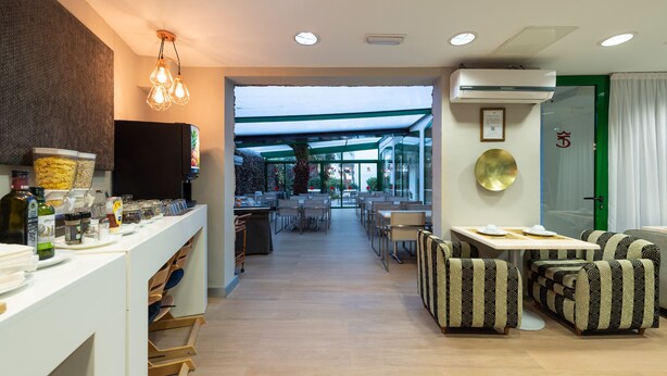 A modern hotel lobby with a reception desk, seating area, and a view of the outdoor space. - Apartamentos Don Diego (San Bartolomé de Tirajana)