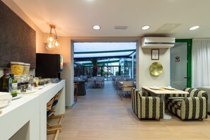 Un vestíbulo de hotel moderno con mostrador de recepción, zona de estar y vistas al espacio exterior.