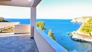 A balcony with a view of the sea, a chair, and a tiled floor. - Sea Front Panorama Villa Private Pool (Malevizi)