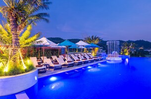 Una piscina al aire libre, sombrillas, tumbonas